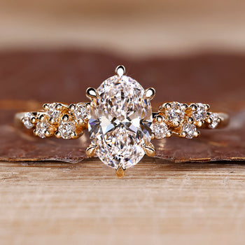 Oval diamond ring with cluster setting and round stones.