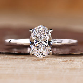 Oval diamond engagement ring with solitaire setting and round cut hidden halo.