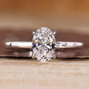 Oval diamond engagement ring with solitaire setting and round cut hidden halo.
