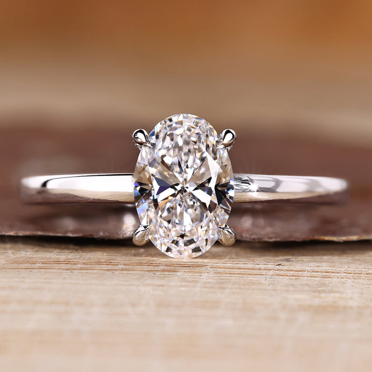 Oval diamond engagement ring with solitaire setting and round cut hidden halo.