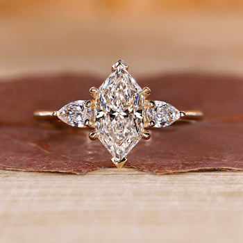 Dutch marquise ring with three stone engagement ring design, featuring V prong setting and four claw prong.
