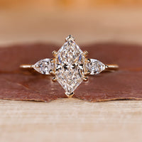 Dutch marquise ring with three stone engagement ring design, featuring V prong setting and four claw prong.
