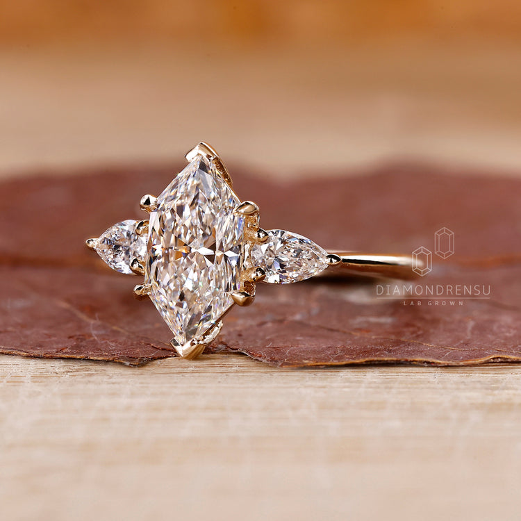 Yellow gold engagement ring with two pear cut side stones, three stone engagement ring, and V prong setting.
