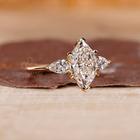 Buy engagement ring with three stone engagement ring design, Dutch marquise ring, and two pear cut side stones.
