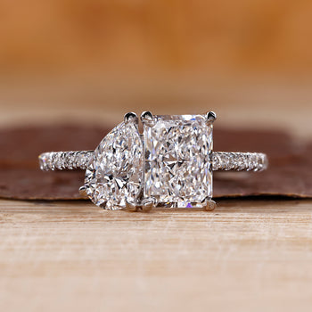 Toi Et Moi engagement ring with pear and radiant diamonds, offering a unique design.
