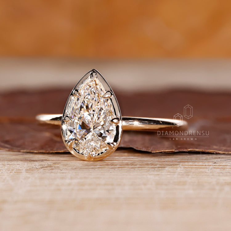 Bezel type prong setting on pear cut diamond engagement ring.
