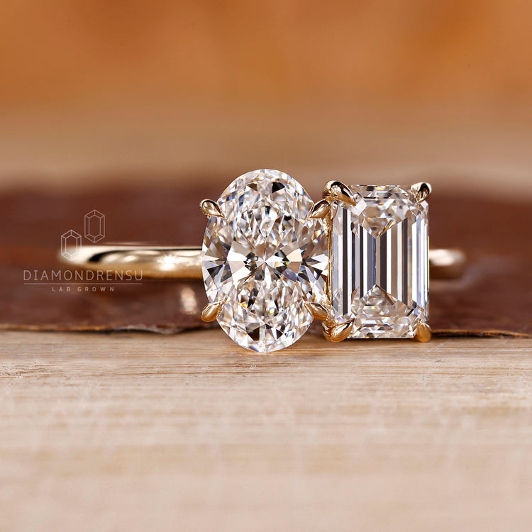 Yellow gold ring with oval and emerald diamonds in claw prong setting.
