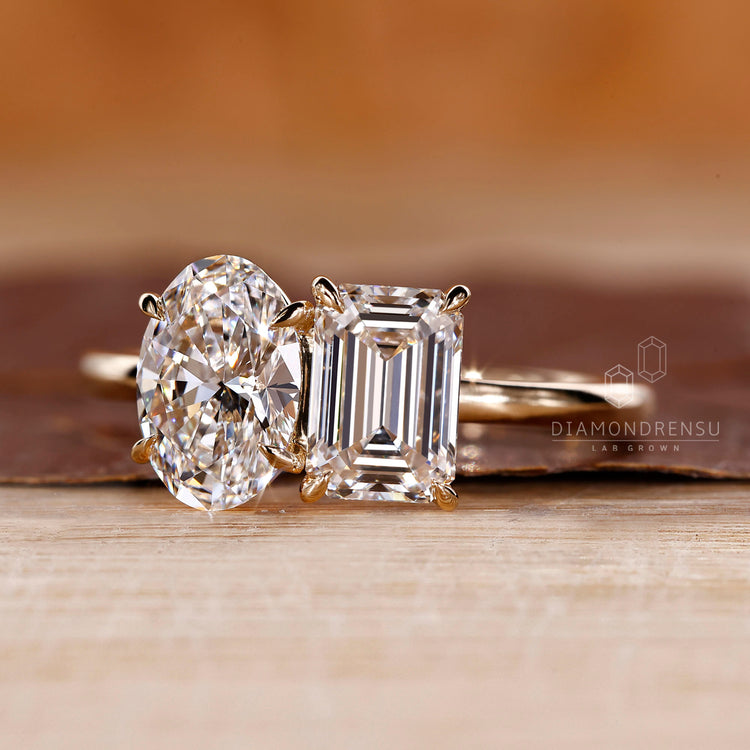 Custom diamond ring with Toi et Moi oval and emerald stones.
