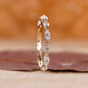 Marquise and round diamond band in a unique half eternity style.

