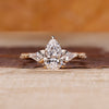 Pear cut engagement ring with three stone design and kite side stone.
