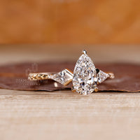 Handmade pear cut engagement ring with kite side stone and art deco.
