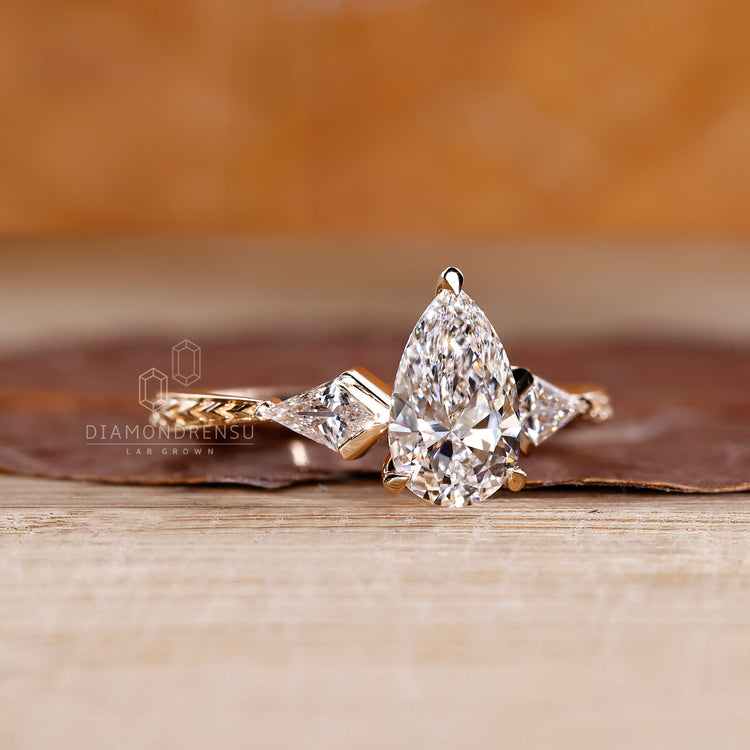 Handmade pear cut engagement ring with kite side stone and art deco.
