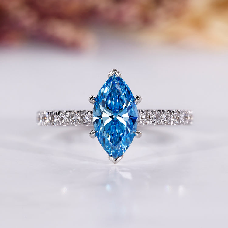 Marquise cut ring with blue diamond and pave setting in white gold.
