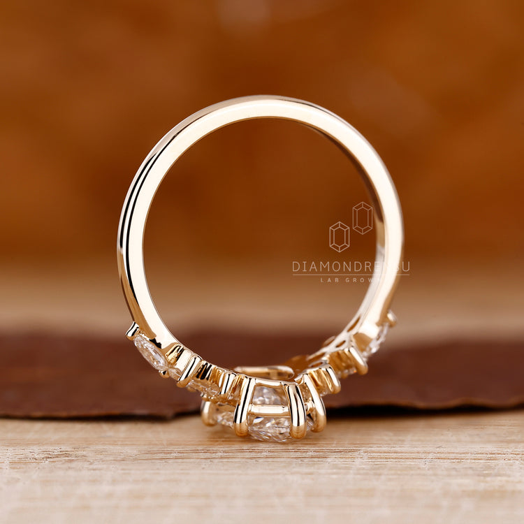 Round and pear side stones accenting marquise center
