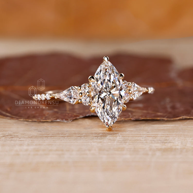 Six claw prong setting holding marquise diamond securely in yellow gold.
