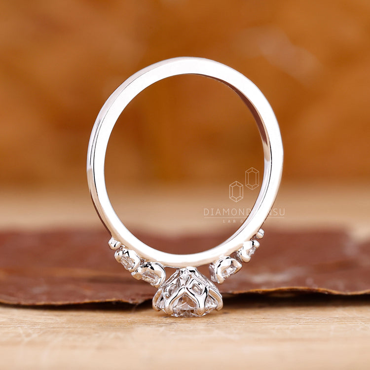 Diamondrensu engagement ring with 5 diamond ring, tapered shank band, and 6 round prong setting in white gold.
