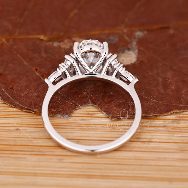 Diamondrensu engagement ring with tapered shank and prong set diamonds.

