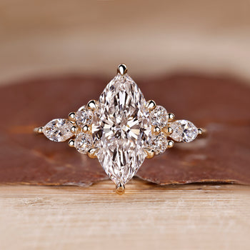 Marquise cut diamond engagement ring with muse setting and round side stones.