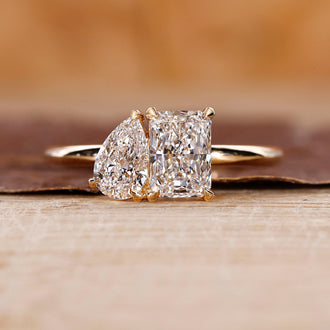 Toi Et Moi Diamond Ring with radiant cut and pear cut diamonds in yellow gold.
