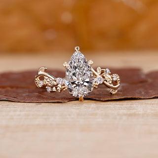 Pear shaped diamond engagement ring in a floral design setting.
