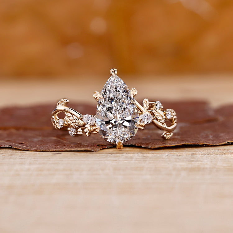 Pear shaped diamond engagement ring in a floral design setting.
