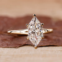 Yellow gold engagement ring with marquise diamond, 6 claw prong setting, and IGI certified lab grown diamond.
