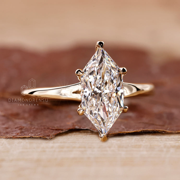 Yellow gold engagement ring with marquise diamond, 6 claw prong setting, and IGI certified lab grown diamond.
