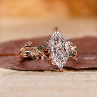 Rose gold engagement ring featuring moss agate and marquise accents.
