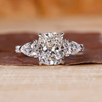 Cushion cut hidden halo engagement ring with lab grown diamond center.
