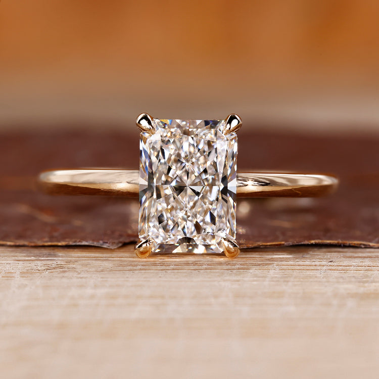 Radiant cut engagement ring featuring solitaire setting and hidden halo diamond.
