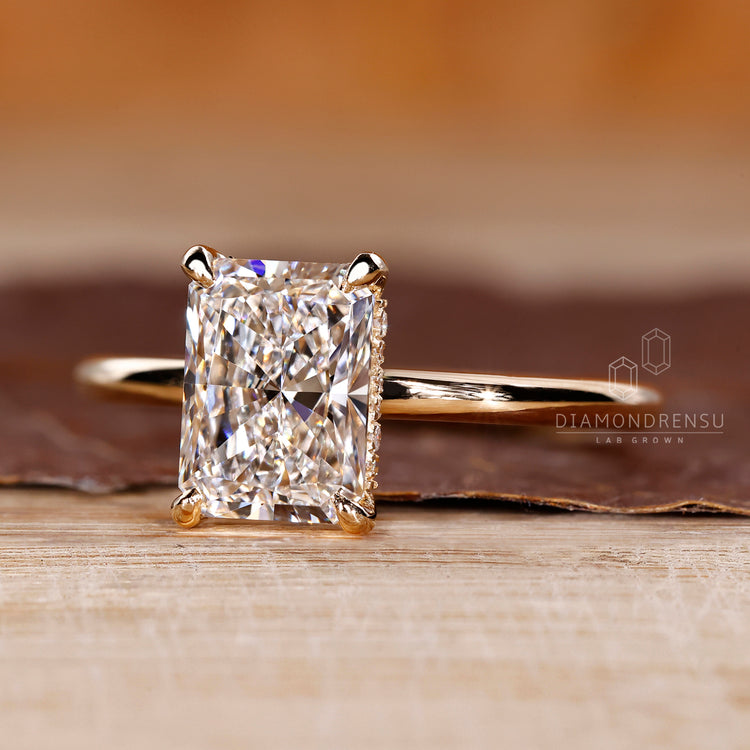 Hidden halo diamond ring with radiant cut solitaire in yellow gold.
