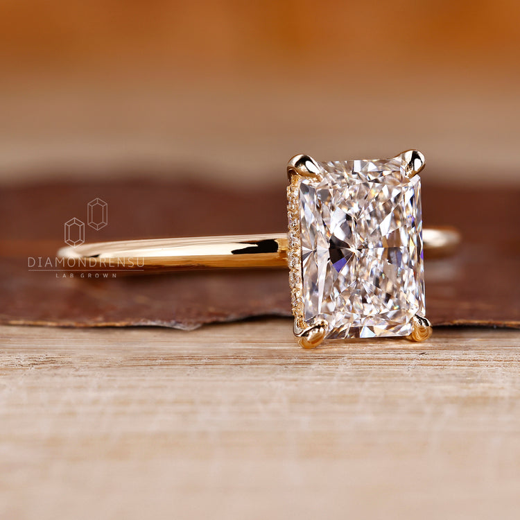 Yellow gold diamond ring with radiant cut solitaire and hidden halo.
