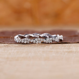 Buy wedding band featuring a twisted design and round diamonds in white gold.
