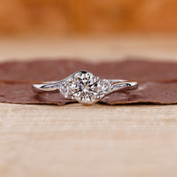 A stunning 3 stone round diamond ring displayed in a classic setting.
