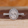 Elongated cushion engagement ring with halo diamond and pave setting details.
