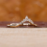 Unique curvy wedding band displayed on a white satin fabric.
