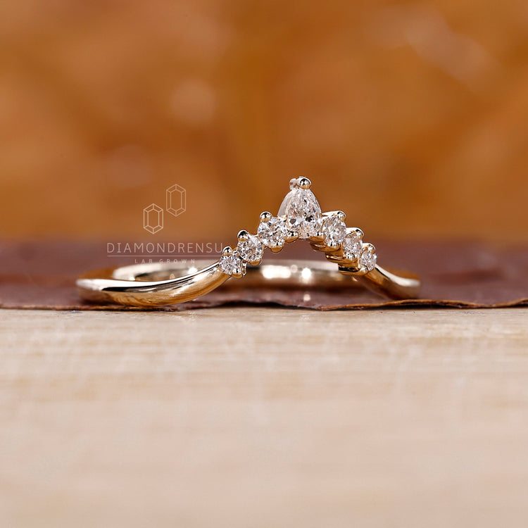 Unique curvy wedding band displayed on a white satin fabric.
