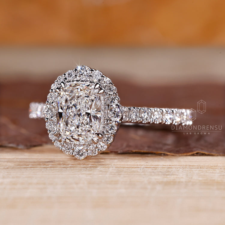 Round diamond halo design in white gold with double claw prong setting.
