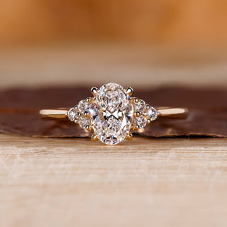 Oval center diamond ring with round side diamonds.
