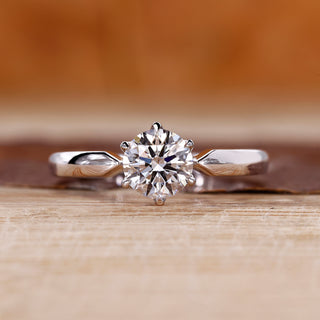 Round diamond solitaire engagement ring with tapered shank and six claw prong.
