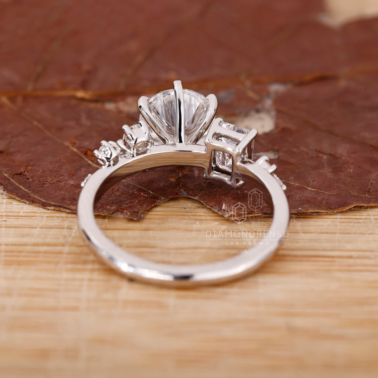 Emerald and round diamond side stones on a lab grown cluster ring
