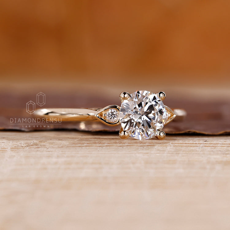 Handmade ring featuring pear shape outline and round side diamonds.
