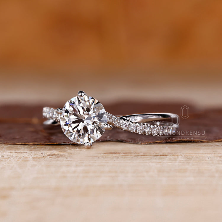 White gold engagement ring with round diamond and elegant pave detail.
