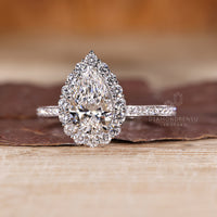 Handmade pear cut engagement ring with round cut pave band.