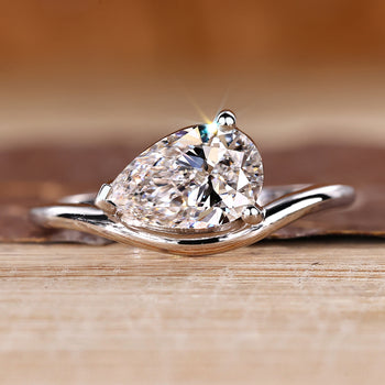 Pear solitaire engagement ring featuring east west setting crafted by Diamondrensu.
