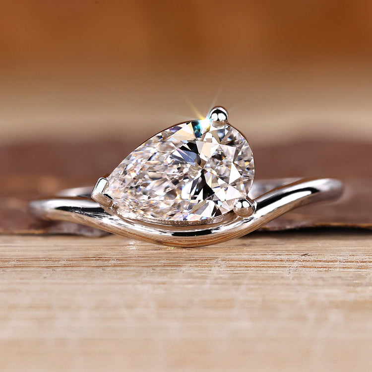 Pear solitaire engagement ring featuring east west setting crafted by Diamondrensu.

