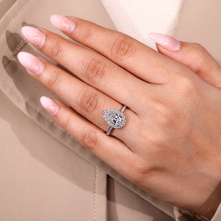 Pear cut engagement ring with lab grown diamond and pave band.