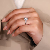 Cushion old mine center diamond with pear side stones and knife edge band.