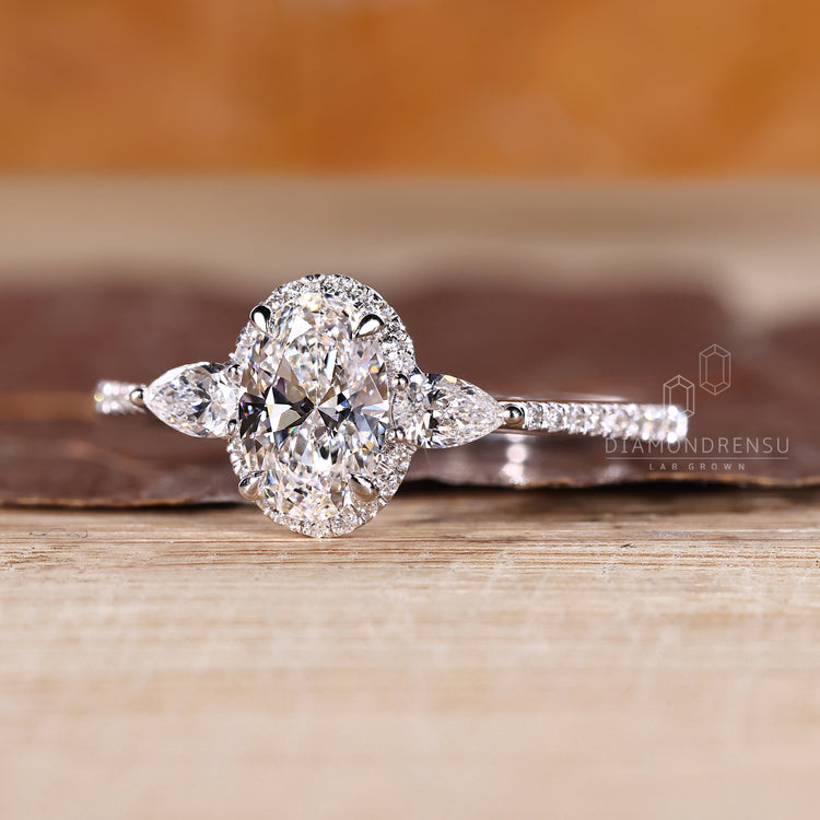 Handmade oval diamond ring with pear side accents.