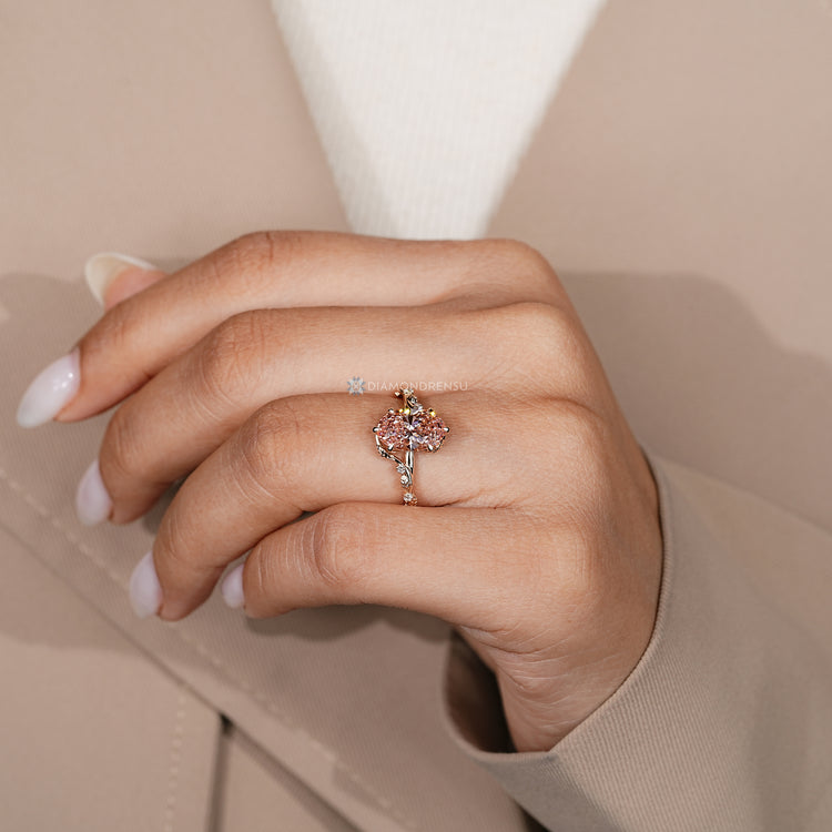 Oval engagement ring with pink diamond and tulip setting.